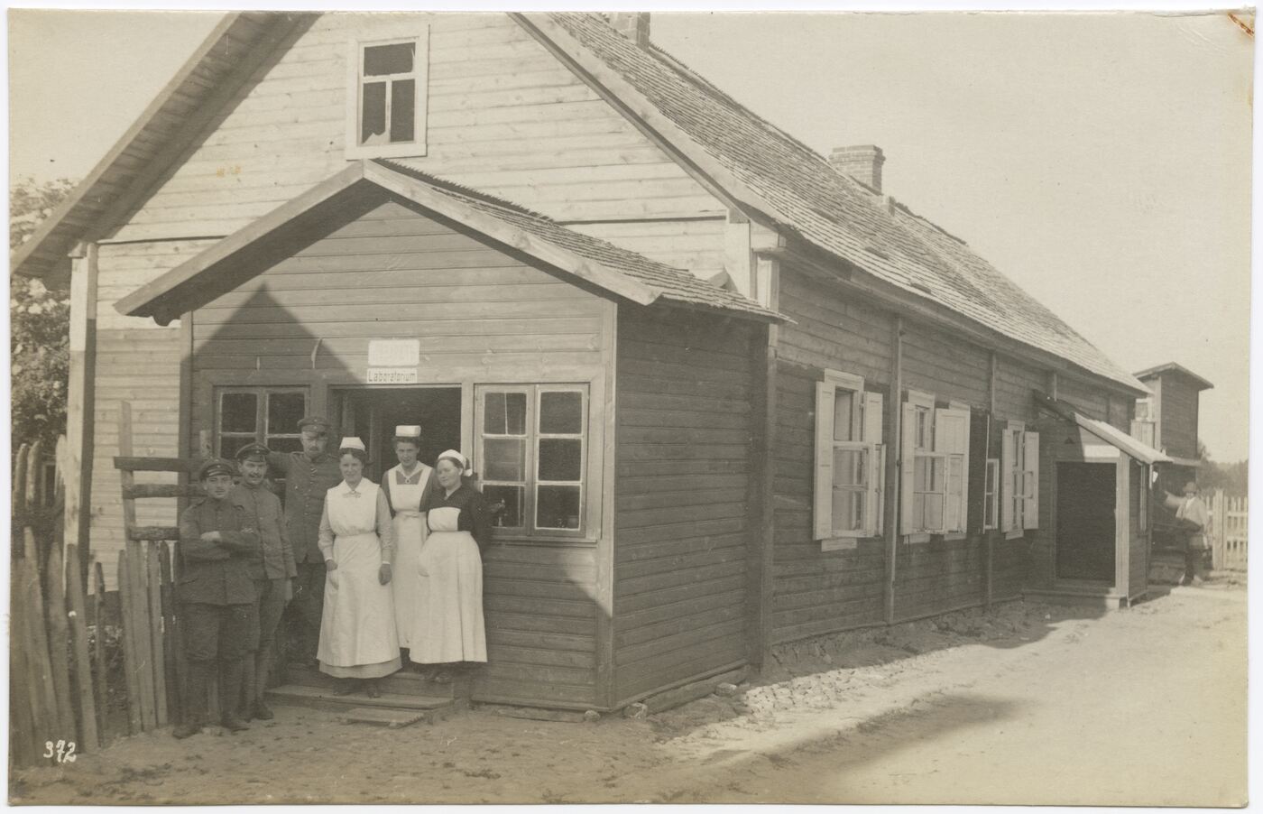 Wilhelm Alb. Bechtel, Kariškių ir virėjų portretas kieme, prie pastato