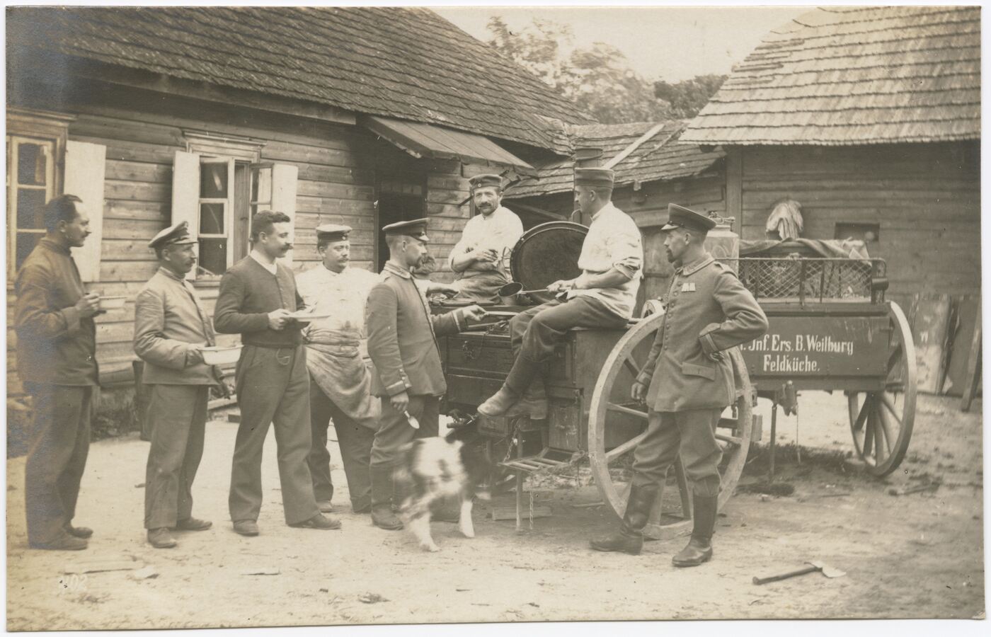 Wilhelm Alb. Bechtel, Kariškių ir virėjų portretas kieme, prie vežimų su maisto katilais